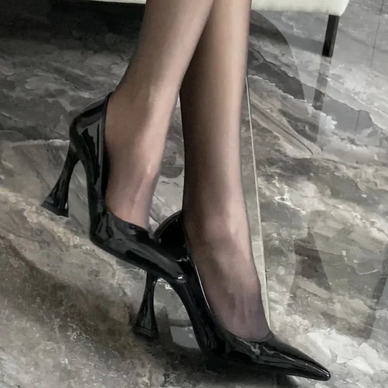 Black high-heeled shoes on a marble floor