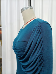 Blue sweater on a mannequin against a white curtain background