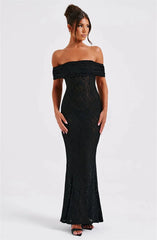 Woman wearing a black off-shoulder lace dress on a white background