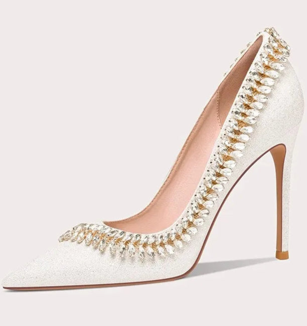 White high-heeled shoe with pearl embellishments on a white background