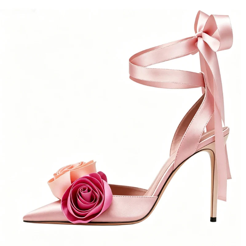Pink satin stiletto sandals with rose embellishments and ankle tie.