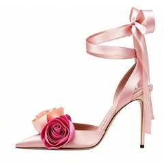 Pink satin stiletto sandals with rose embellishments and ankle tie.