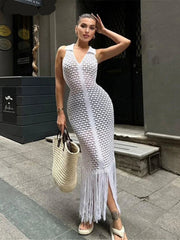 Woman wearing a white beaded dress with fringe, standing on a street.