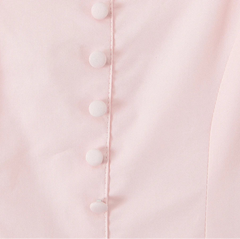 Close-up of a light pink garment with white buttons.