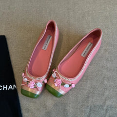 Pink square toe flats with green and gold accents and floral embellishments.
