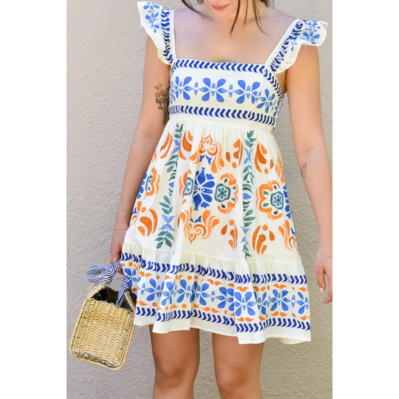Woman wearing a colorful dress with floral patterns against a neutral background