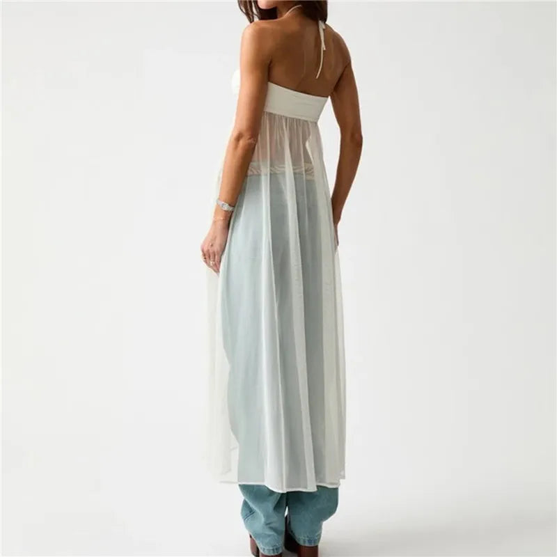 Woman wearing a light blue and white dress with sheer overlay on a white background