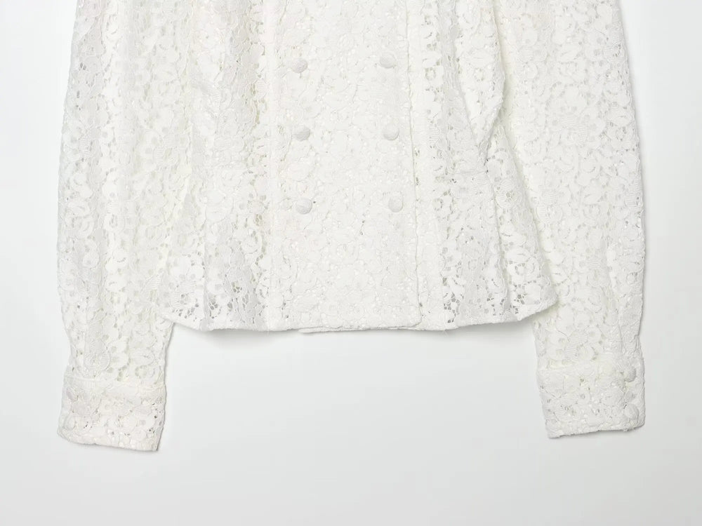 Detail of the hem and sleeves on a white lace double-breasted cropped jacket.