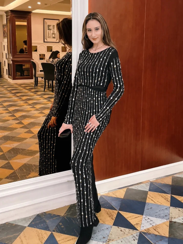 Woman in a black and white patterned dress standing in a room with a checkered floor.