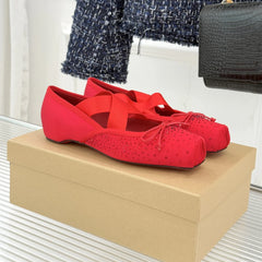 Red ballet flats on a beige shoe box with a blurred background