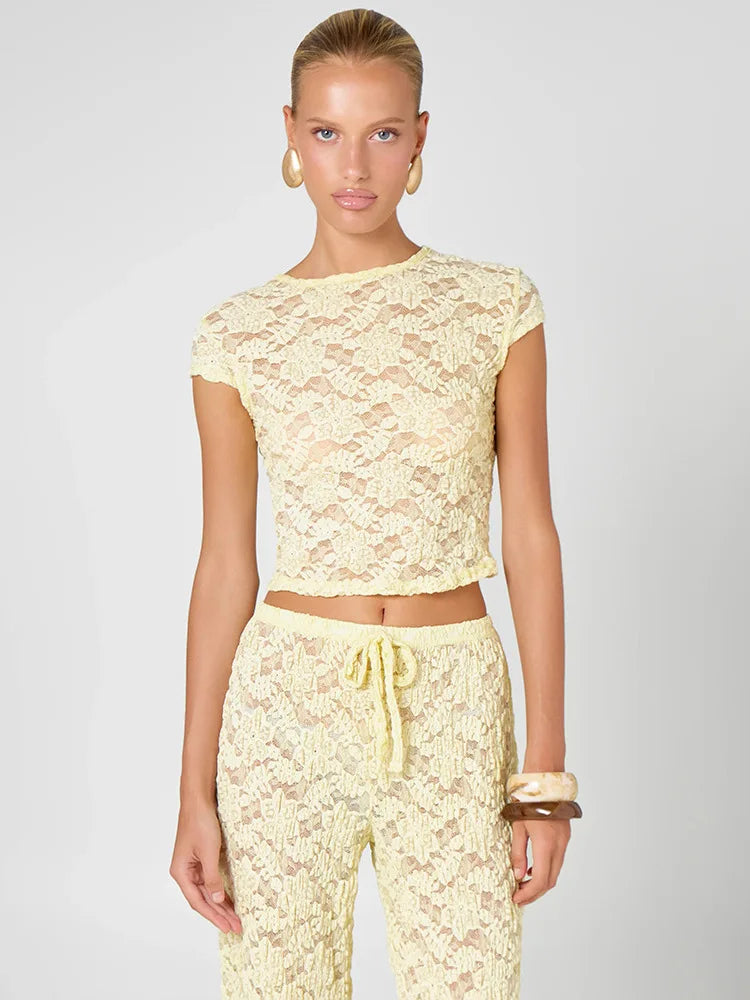 Close-up of a yellow lace cropped t-shirt and wide leg pants set.