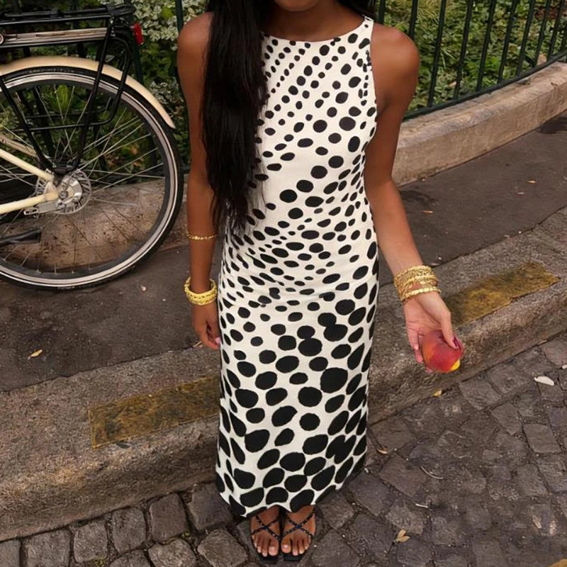 Dot print sleeveless maxi dress worn outdoors with cobblestone street