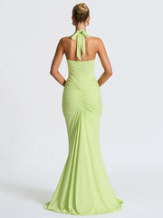 Woman wearing a light green evening gown with a halter neck design on a white background