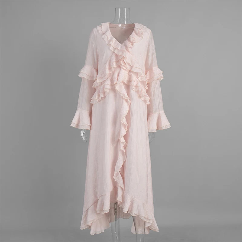 Pink ruffled dress on a mannequin against a gray background