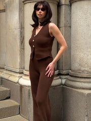 Woman in a brown outfit standing on stone steps.