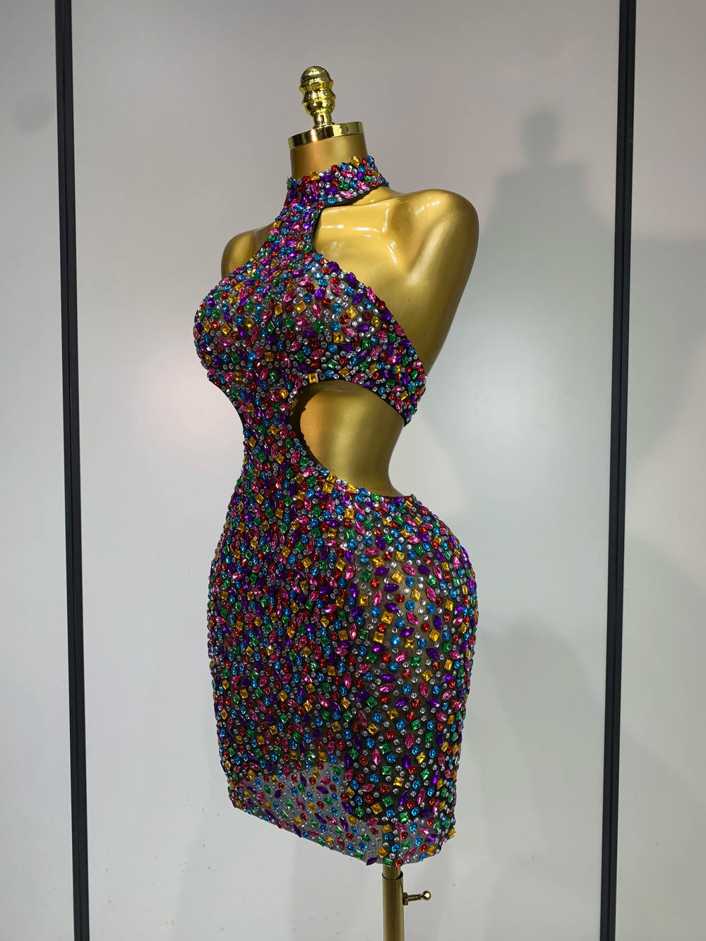 Side view of halter neck rhinestone mini dress with cut-out details