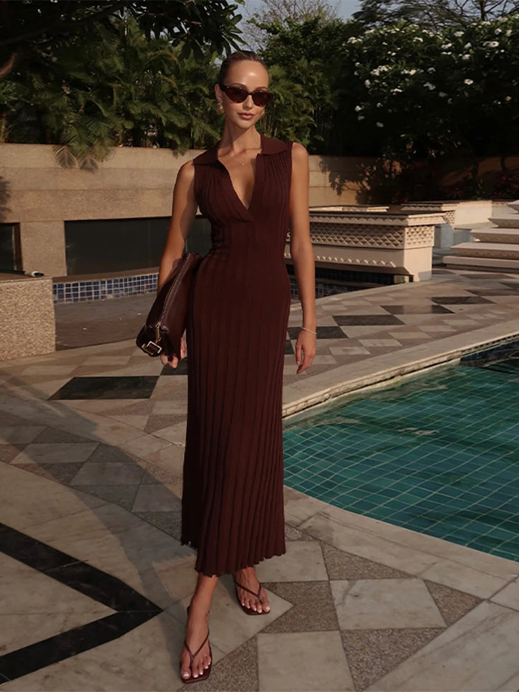 Woman in a brown dress standing by a poolside
