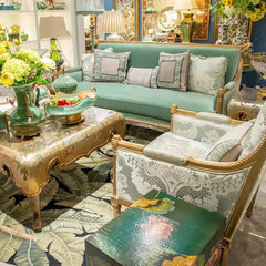 Decorative living room with a green sofa, ornate coffee table, and patterned rug.