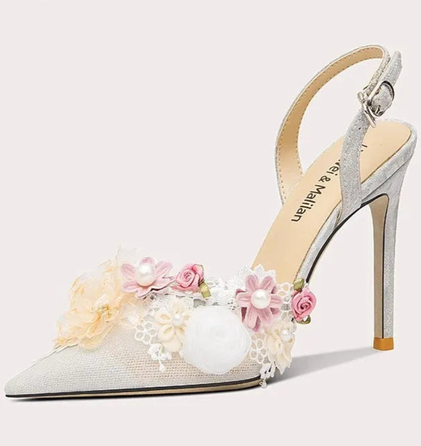 High-heeled shoe with floral decorations on a light gray background