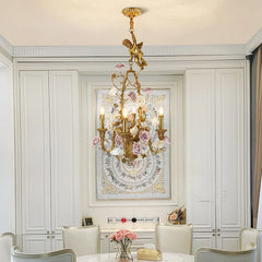 Elegant dining room with a gold chandelier, floral artwork, and white furniture.