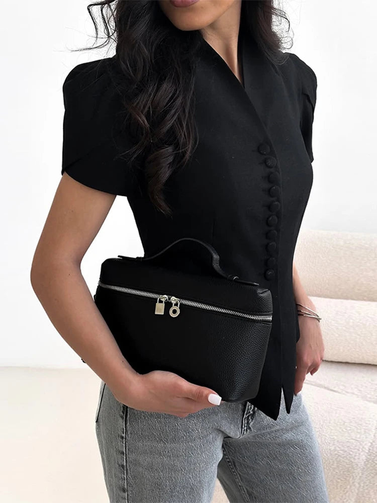 Person holding a black waist bag with a neutral background