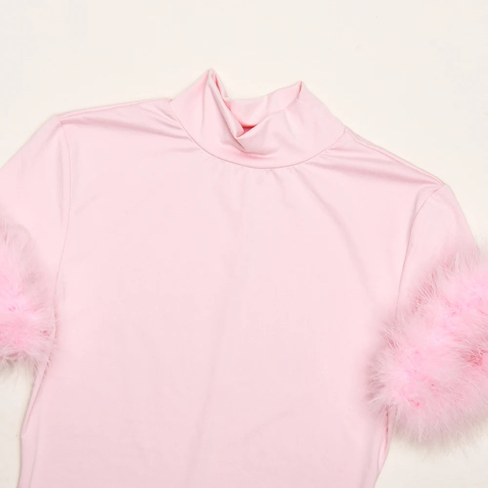 Pink long-sleeve top with feather details on a white background