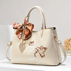 A luxurious embroidered leather shoulder bag with intricate detailing, showcased against a neutral background.