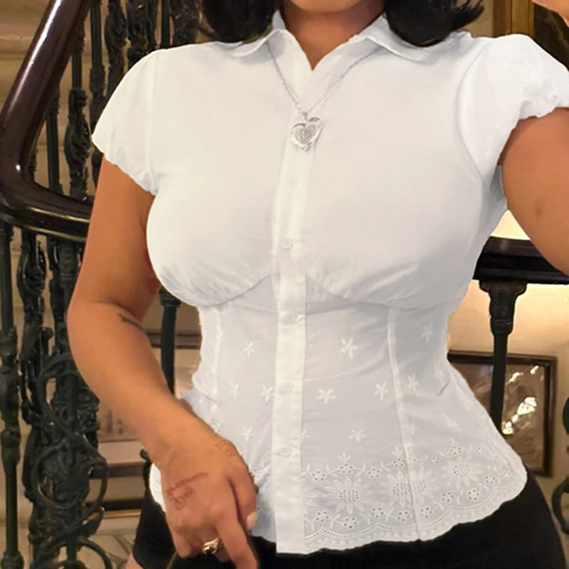 Woman wearing white cinched waist button-up shirt with embroidery, fitted silhouette blouse for summer.