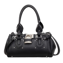 Black structured riveted lock bag with top handles and detachable strap.