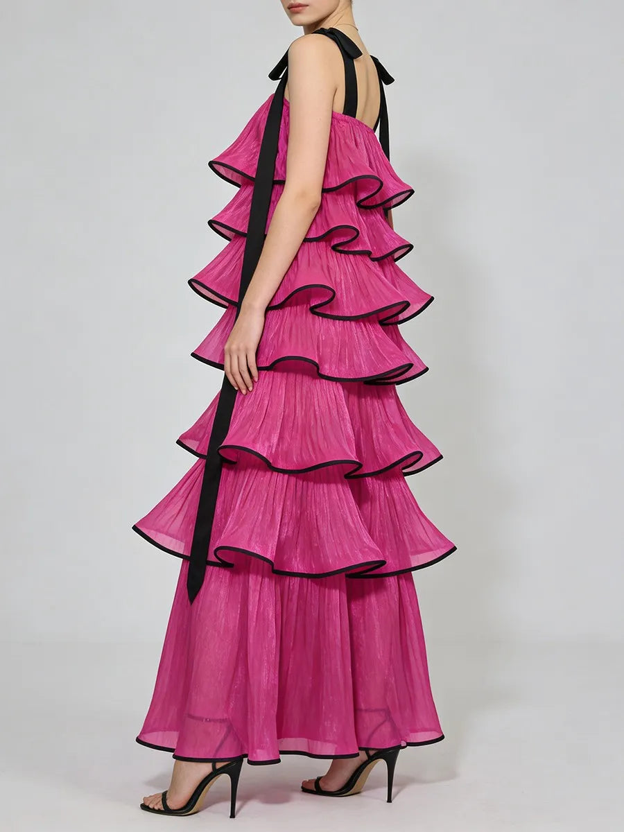 Pink ruffled dress with black trim on a white background