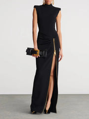 Black evening gown with a high slit and gold belt on a plain background