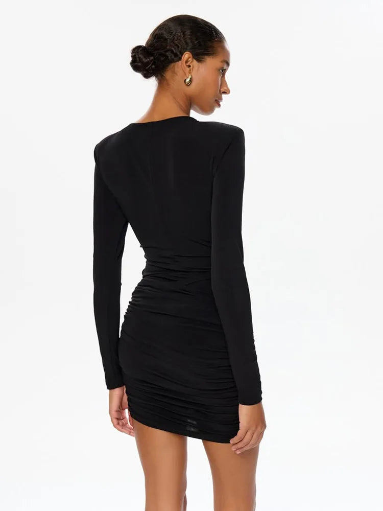 Woman wearing a black long-sleeve dress on a white background