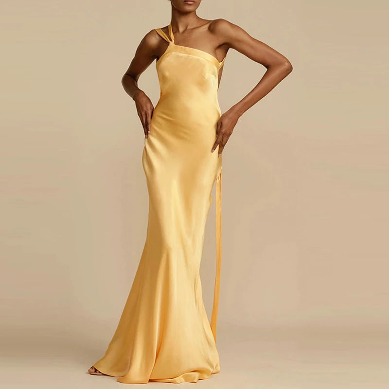 Woman wearing a yellow satin gown against a beige background