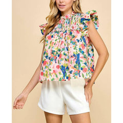 Woman wearing a colorful floral blouse with ruffled sleeves