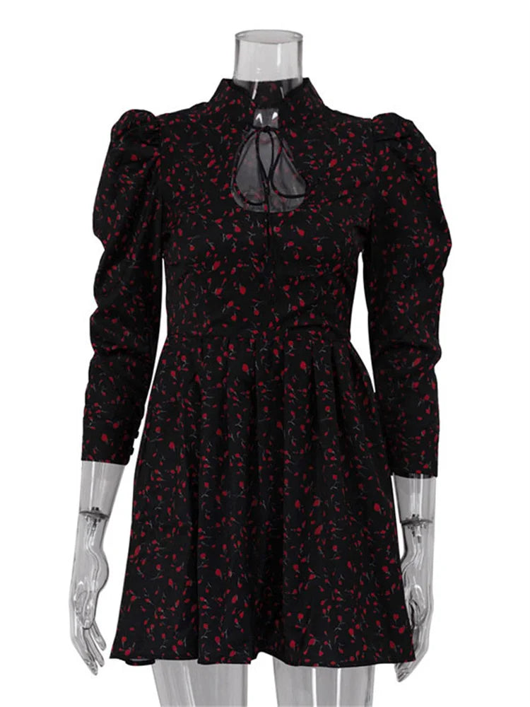Black dress with red floral pattern on a mannequin against a white background