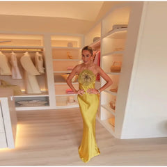 Woman in a yellow dress standing in a well-lit closet.
