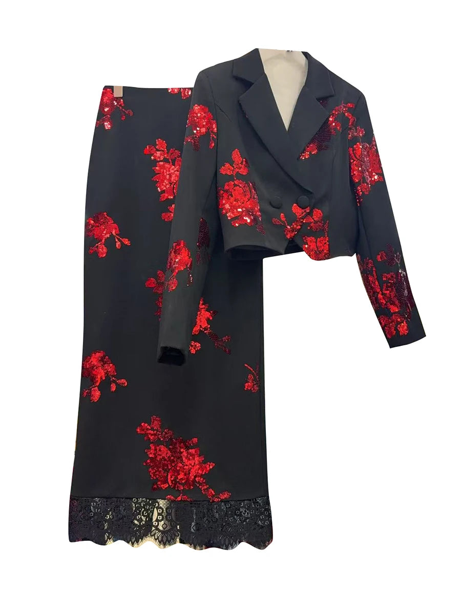 Black outfit with red floral embroidery on a white background