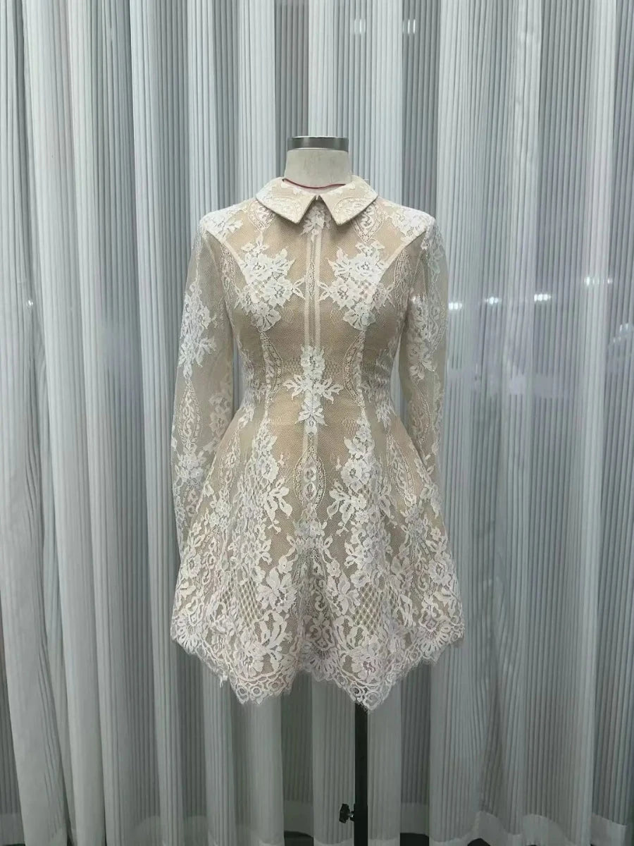 Lace dress on a mannequin against a white curtain background