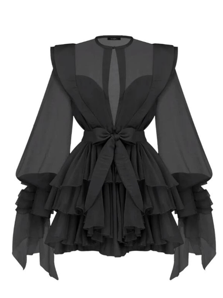 Black dress with ruffled layers and sheer sleeves on a white background