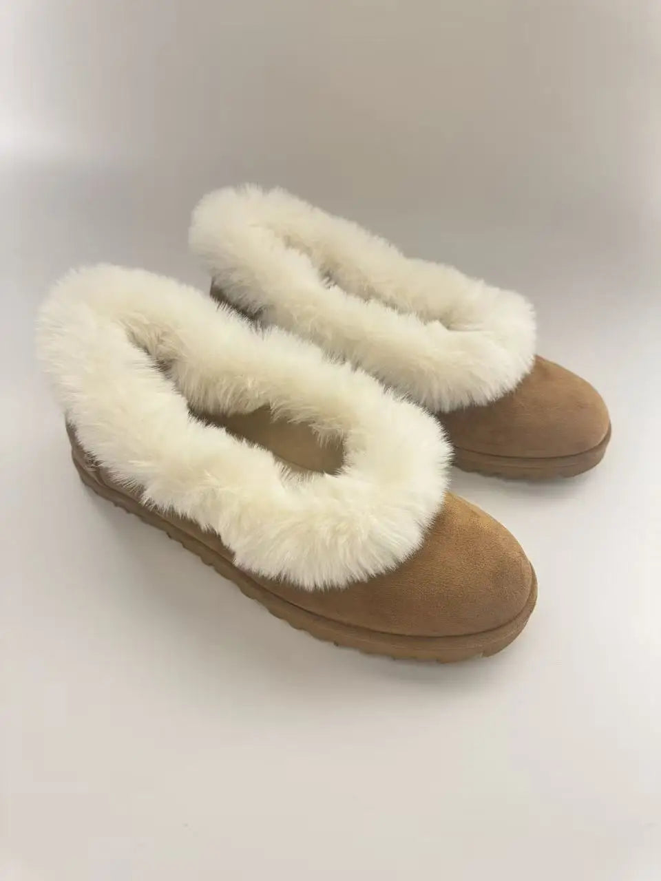 Fur trimmed suede ballet flats on a white background