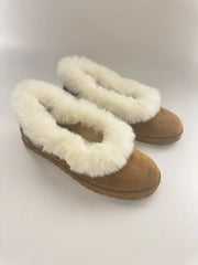 Fur trimmed suede ballet flats on a white background