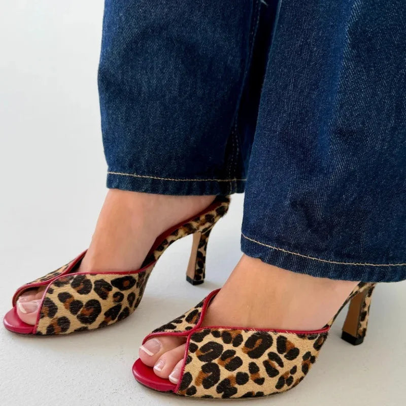Leopard print peep toe mule heels on feet with blue jeans