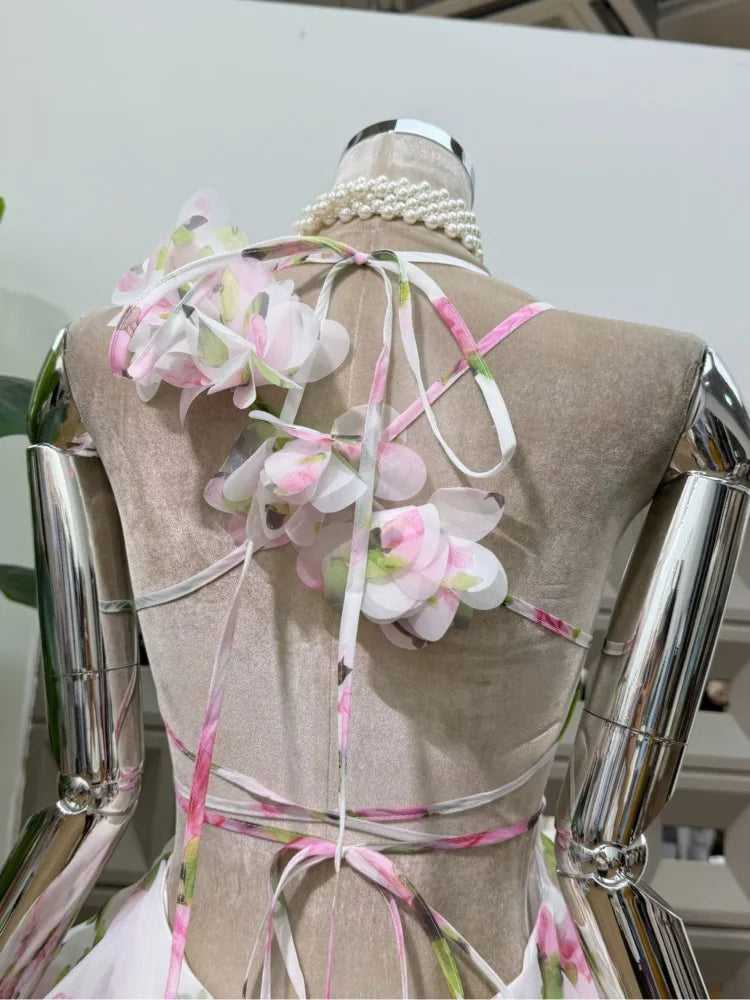 Back view of a floral print halter neck mini dress showing tie closures and blossom details.