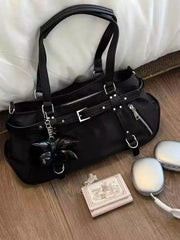 Black handbag with decorative elements on a wooden surface