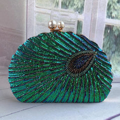 A close-up of a vintage-style clutch bag, showcasing intricate bead embroidery and a clasp closure