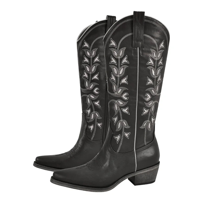 Black cowboy boots with intricate white embroidery on a white background