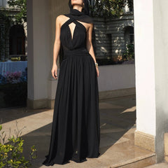 Woman wearing a black evening gown standing outdoors.