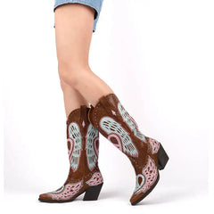 Brown cowboy boots with decorative patterns on a white background