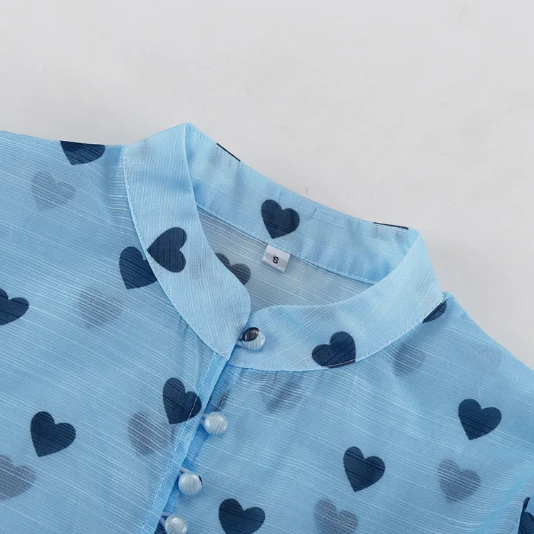 Light blue garment with dark blue heart patterns on a light gray background