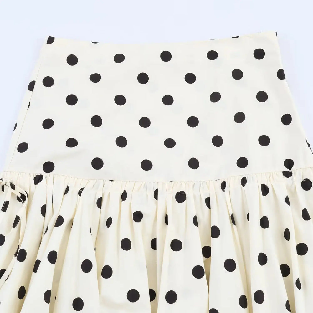 White skirt with black polka dots on a light blue background